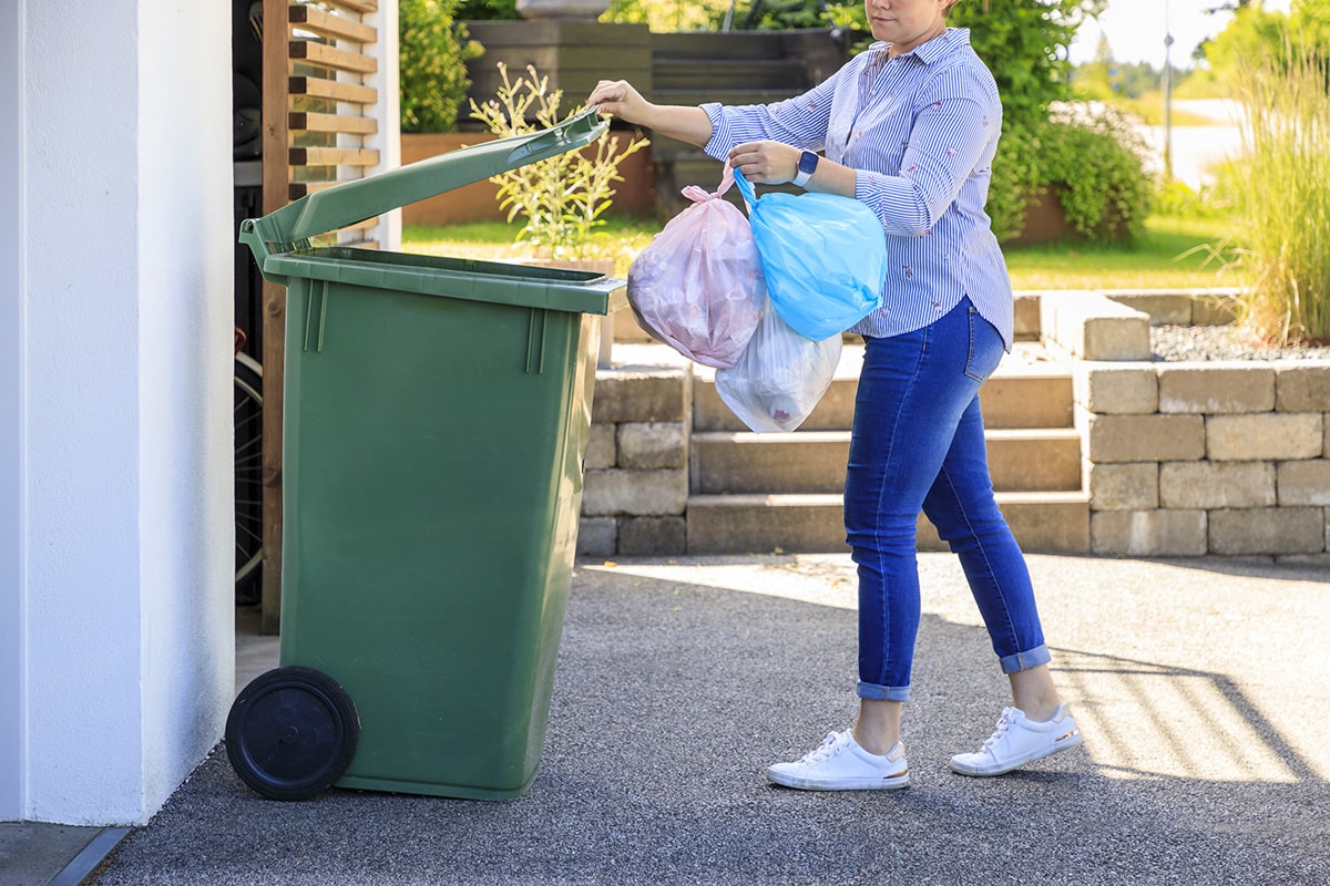 Kvinna slänger sopor