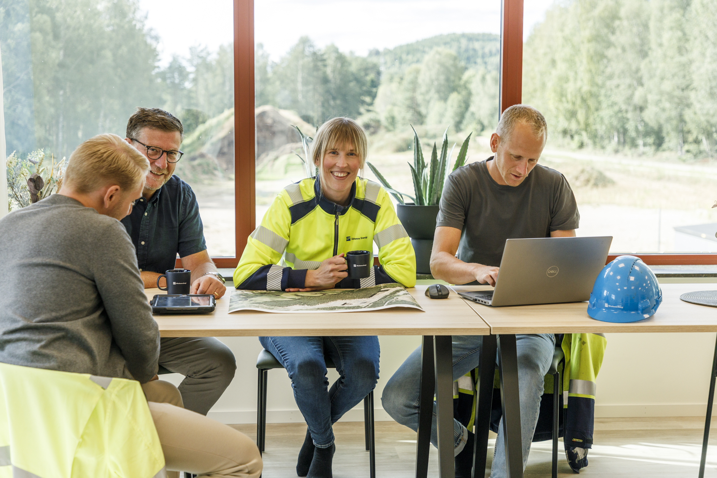 EE-UEAB-VA2025-8952-webb Fyra personer sitter i ett konferensrum och diskuterar vid en dator