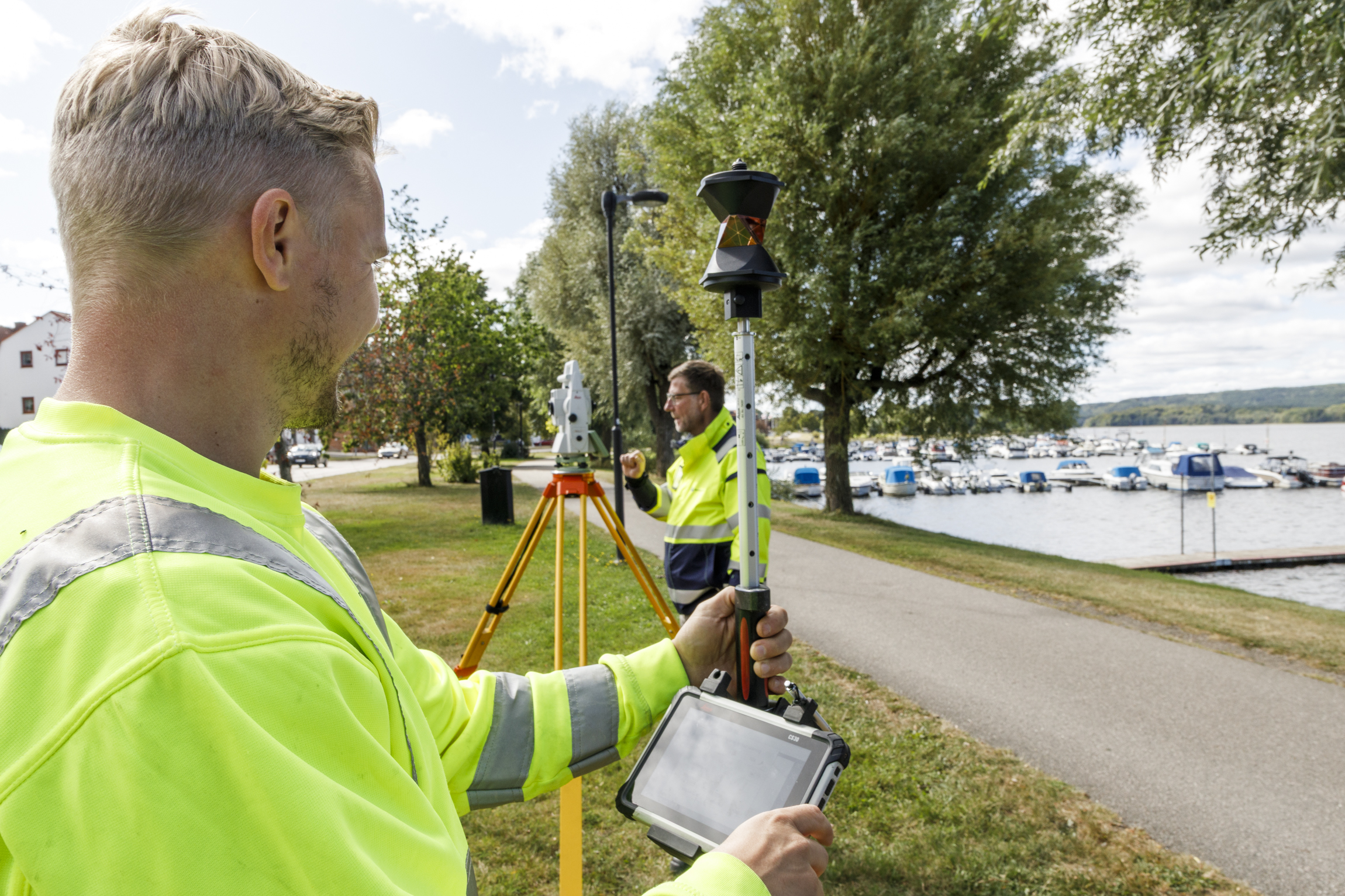 EE-UEAB-VA2025-9146-webb Två män i varselkläder mäter ut ledningsdragning vid banvallen Ulricehamn