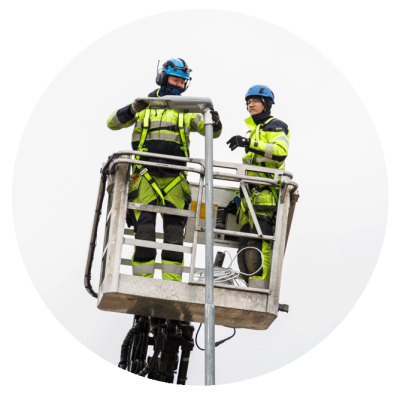 Två män installerar en gatubelysningsarmatur