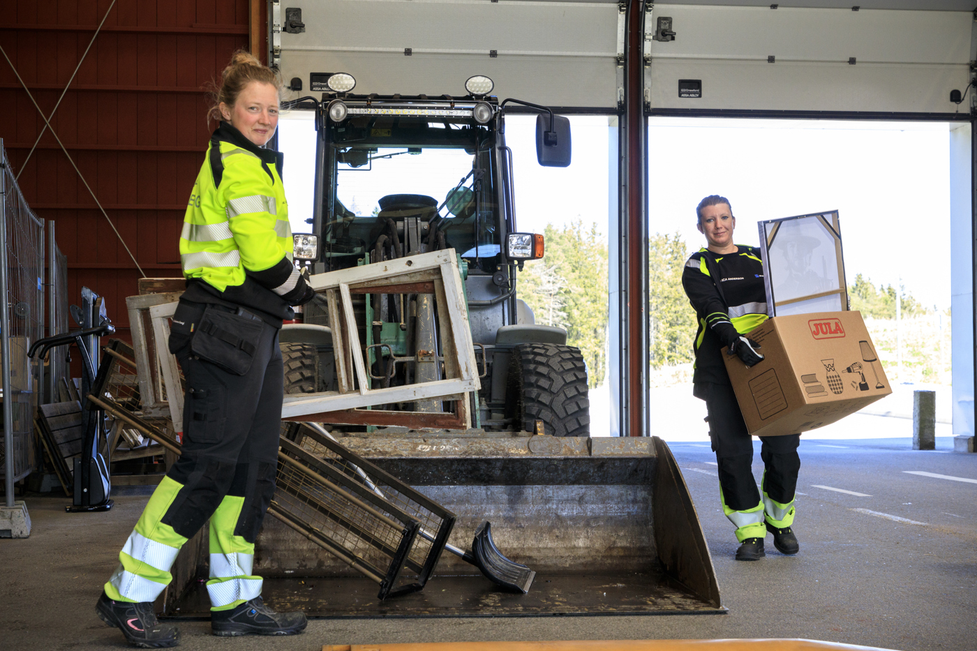 Två tjejer i ankomsthallen på återvinnignscetralen övreskog. Bär fönster för återbruk.